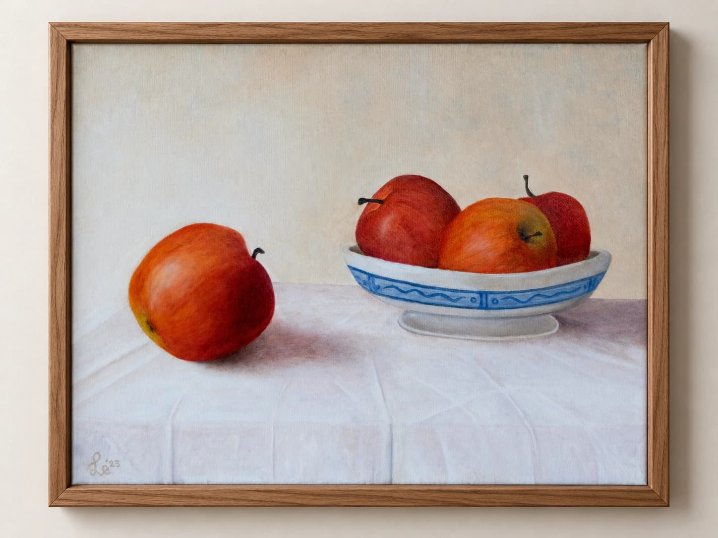 Rode appels in een wit-blauwe schaal op wit linnen, in een houten lijst.